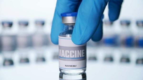 Close up, Scientist is holding a glass vial for vaccine in laboratory.
