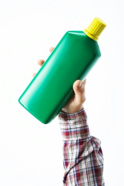 Hand holding a fertilizer bottle